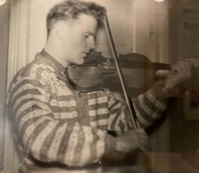 En ung Jon i Selbukofte spiller fiolin